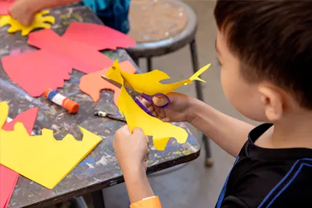 fms-scissors Child cutting paper with scissors