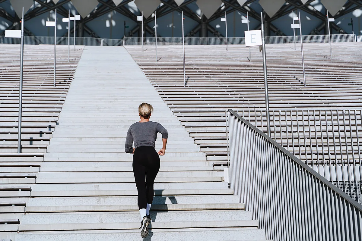 Woman running up the stairs in a stadium